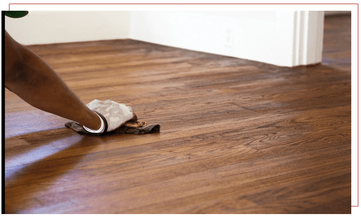 A person sanding the floor of their home.