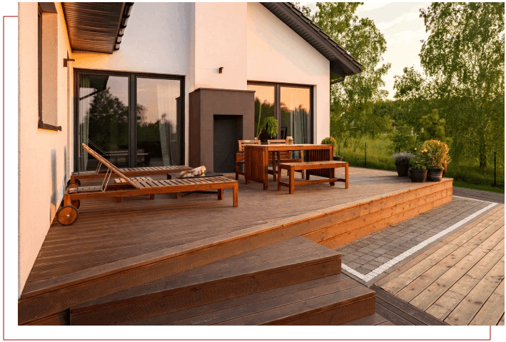 A deck with chairs and tables outside of the house.